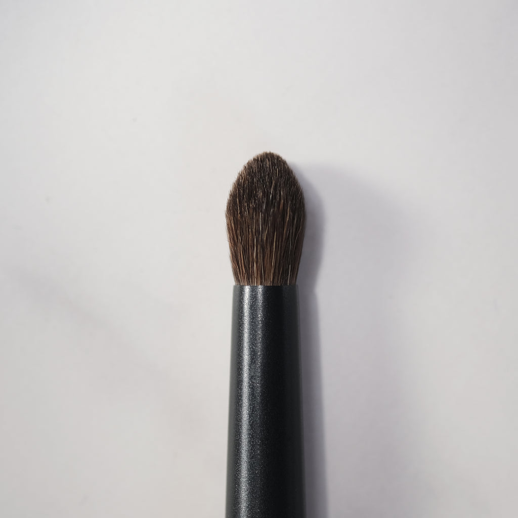 Makeup brush with brown bristle head on a white background
