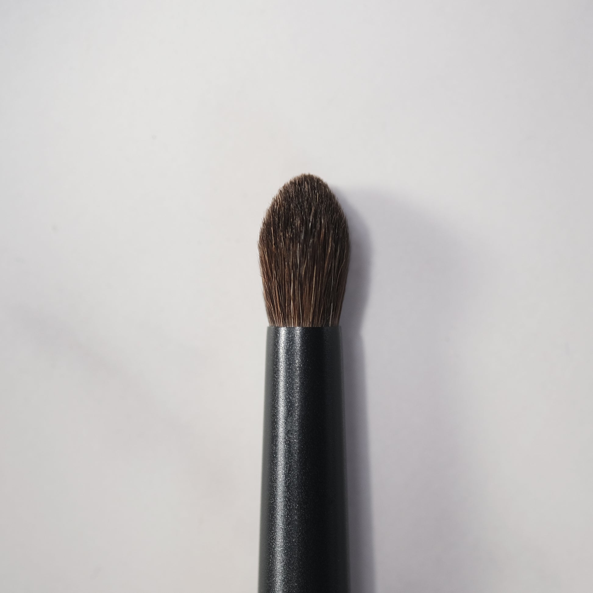 Makeup brush with brown bristle head on a white background