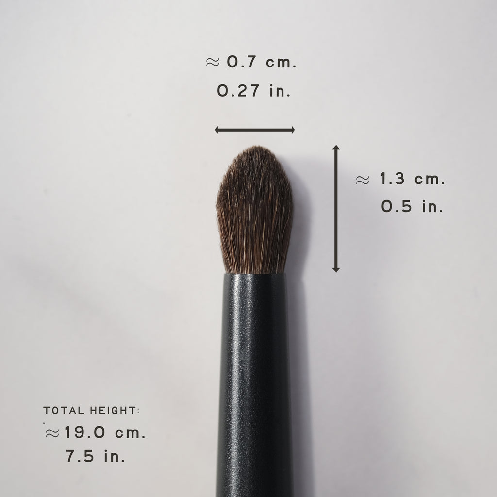Makeup brush with measurements on a light gray background