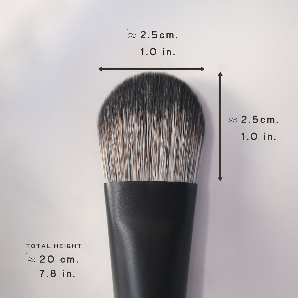 Black makeup brush with measurements on a light gray background
