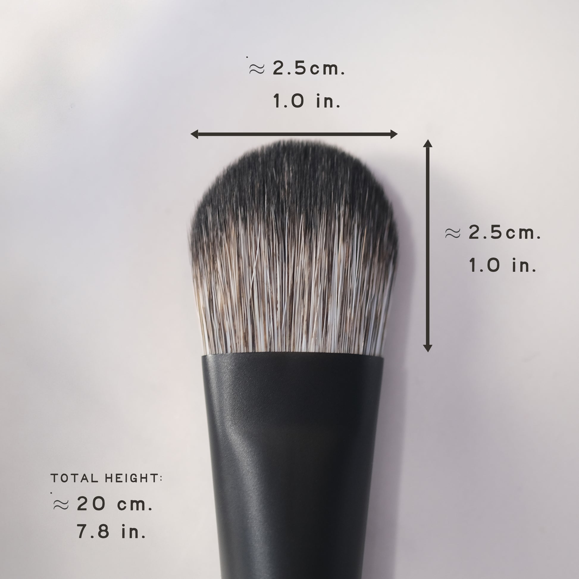 Black makeup brush with measurements on a light gray background