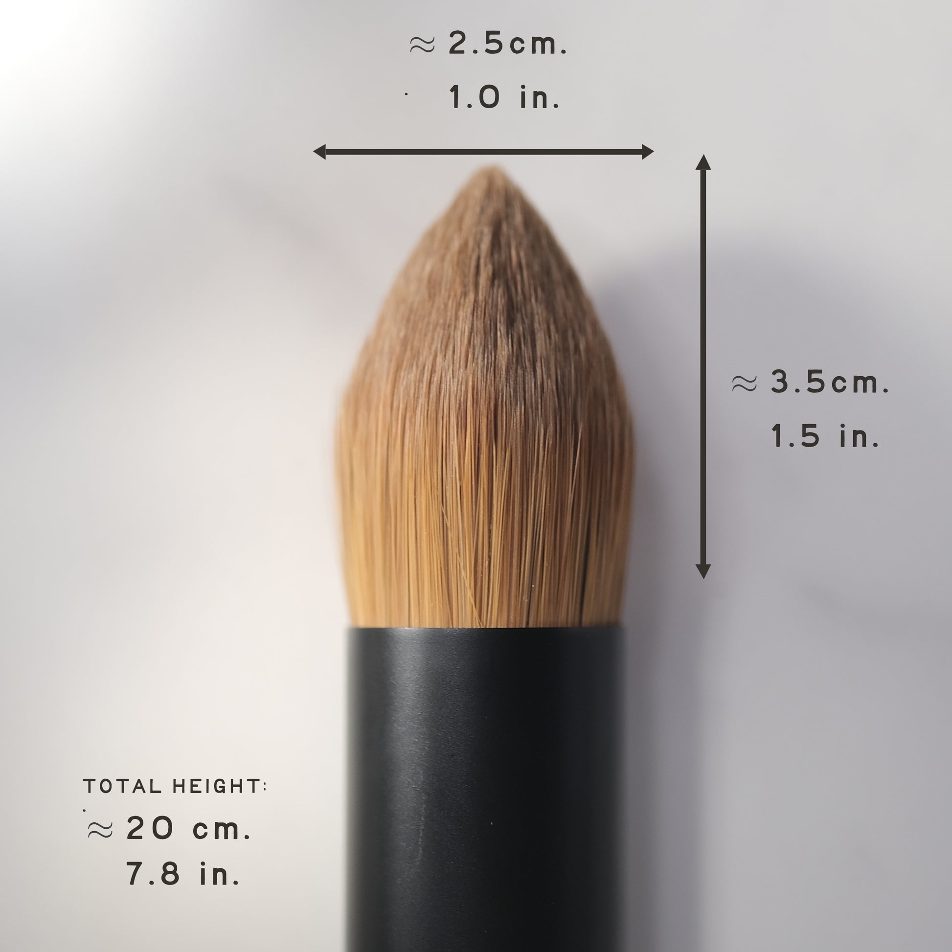Makeup brush with measurements on a gray background