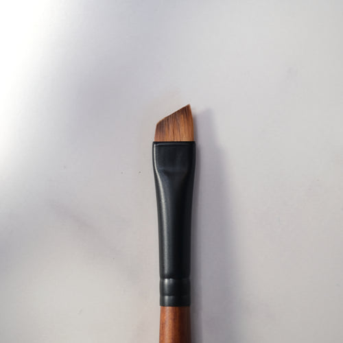 Makeup brush with wooden handle and black ferrule on a white background