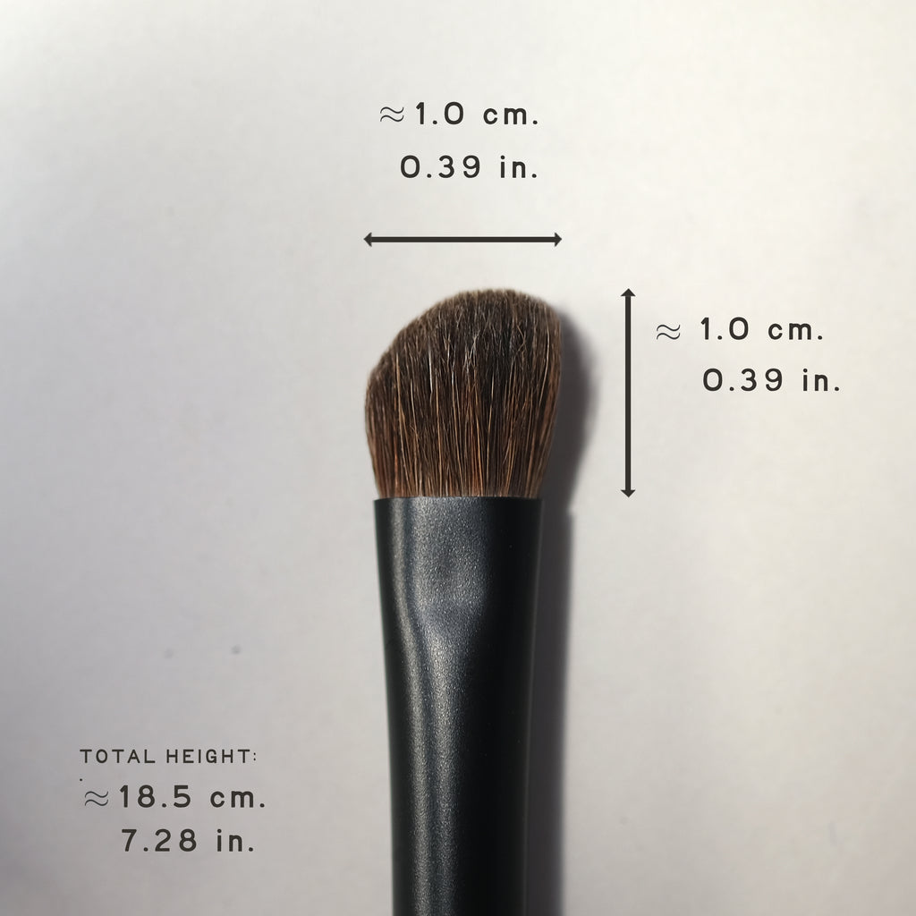 Makeup brush with measurements on a light gray background