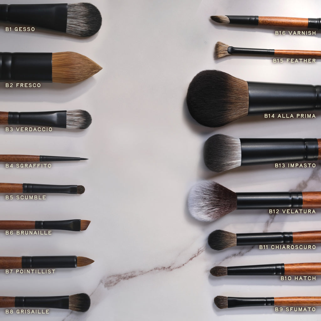 Set of makeup brushes with labels on a marble surface